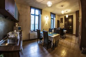 a kitchen and dining room with a table and chairs at Belvárosi Vendégház in Szekszárd