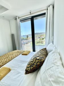 a bedroom with a bed and a large window at Private Front Beach Villa with garden and garage in Antibes