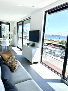 a living room with a couch and a view of the ocean at Private Front Beach Villa with garden and garage in Antibes
