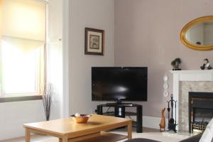 a living room with a tv and a coffee table at St Leonard's self catering apartment in Largs