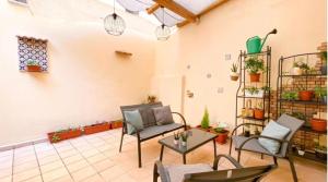 a living room with chairs and tables and potted plants at Le Scale della Minerva in Salerno