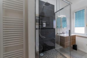 a glass shower in a bathroom with a sink at Lumen, few steps to the walls, 2 bath, 3 SmartTV, High Speed Fiber, AC in Lucca