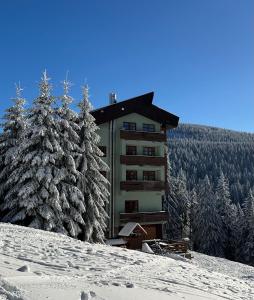 a building on top of a snow covered mountain at Apartmán v Srdci Hor Cihlářka in Pec pod Sněžkou