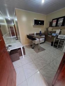 a living room with a table and a desk at Kitnet_Familiar 2/4 in Boa Vista +13 photos