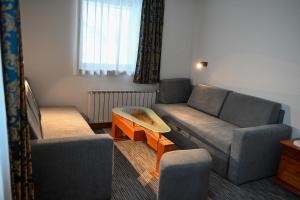 un soggiorno con un divano e un tavolo di Hotel Kristal a Jahorina Altre 90 foto