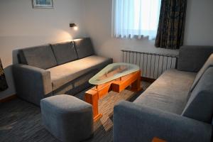 a living room with two couches and a coffee table at Hotel Kristal in Jahorina