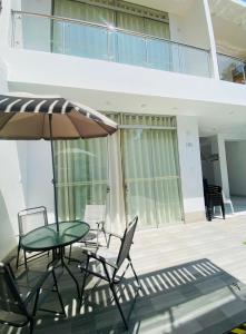 a patio with a table and chairs and an umbrella at Hurin Perú in Ica