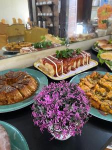 a table topped with plates of food and pastries at Pousada Granada in Rio das Ostras