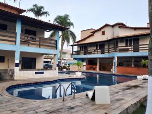 a swimming pool in front of a building at Pousada Granada in Rio das Ostras
