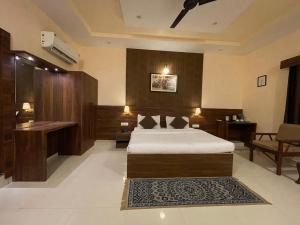 a hotel room with a bed and a desk at House M Lodge in Sawāi Mādhopur