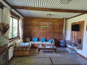 una sala de estar con un sofá y una mesa en Cabaña Canto del Zorzal, en Villarrica