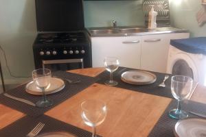 a table with wine glasses on top of a kitchen at Charme et Douceur en Provence in Saint-Étienne-les-Orgues