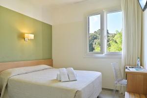 Postel nebo postele na pokoji v ubytování Hôtel de Porticcio