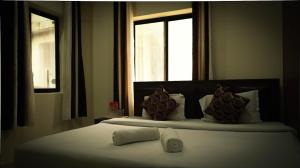 a bedroom with a large bed with two windows at Moksh Ganga in Rishīkesh +15 photos