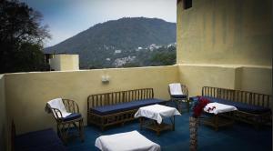 a group of chairs and tables on a balcony at Moksh Ganga in Rishīkesh