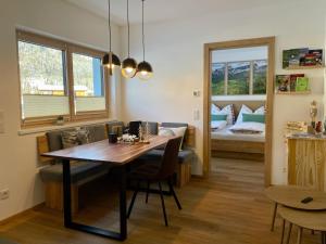 a dining room with a table and a bedroom at Beagzeit Ferienwohnung in Lofer