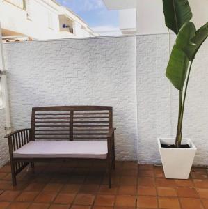 a bench sitting on a patio with a potted plant at casa en Islantilla in Isla Cristina