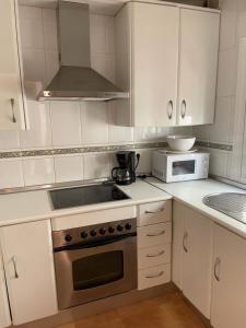 a kitchen with a stove and a microwave at casa en Islantilla in Isla Cristina