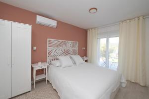 a bedroom with a white bed and a window at Villa Zen Oaza in Poljica +55 photos