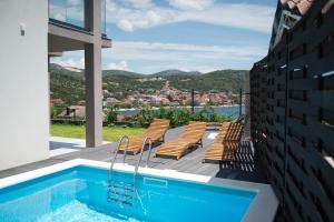 a house with a swimming pool on a balcony at Villa Zen Oaza in Poljica