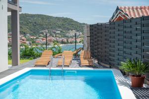 a swimming pool with chairs and a view of a city at Villa Zen Oaza in Poljica