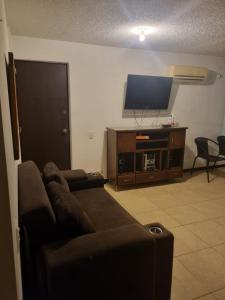 een woonkamer met een bank en een flatscreen-tv bij Apartasol Familiar 2 in Santa Fe de Antioquia