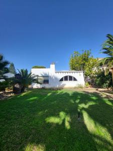 a white house with a green lawn in front of it at Casa Nieves in Roquetas de Mar