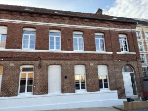 a brick building with white doors and windows at Appartement des Capucins in Cambrai