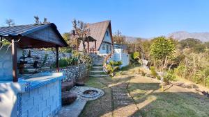 a backyard with a stone wall and a house at Coco Homes Katra in Katra
