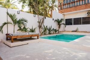 a pool with a bench next to a building at Casa Madre Selva in Brisas de Zicatela