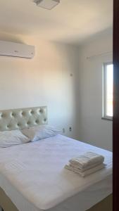 a white bed with white sheets and a window at Fortal Flat in Fortaleza +42 photos