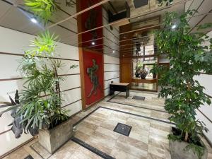 a lobby with plants and a red door at Departamento en Nueva Córdoba in Cordoba