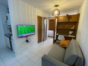 a living room with a couch and a television on a wall at Departamento en Nueva Córdoba in Cordoba