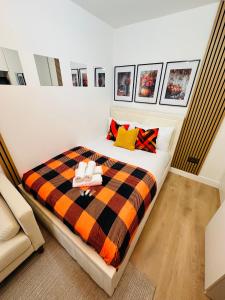 a bedroom with a bed with a checkered blanket at R4 - Elegant Private Room with Kitchenette near QE Hospital Harborne in Birmingham +12 photos