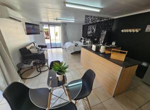 a kitchen with chairs and a counter in a room at Moo Manor in Kimberley
