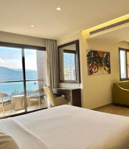 a bedroom with a bed and a desk and a window at Opera Hotel in Tabarja