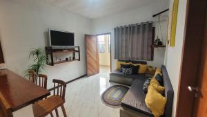 ein Wohnzimmer mit Sofa und Tisch in der Unterkunft Casa de Praia na Roça in Angra dos Reis