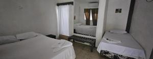 mały pokój z 2 łóżkami i lustrem w obiekcie Hotel Adelmo's w mieście La Entrada