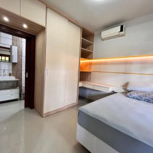 a bedroom with a bed and a bathroom with a sink at Casa do vivi 1 in Tramandaí