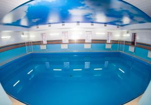 una piscina cubierta con un mural en el techo en Wellness Hotel en Tula