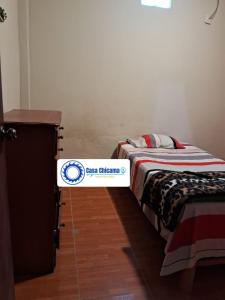 a bed in a room with a sign on it at Casa Chicama in Puerto Chicama