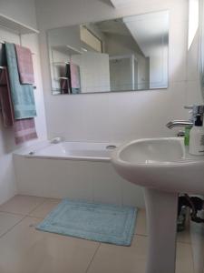 a white bathroom with a sink and a mirror at Chuu's Cosy Place in East London +19 photos