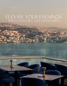 a restaurant with tables and chairs and a view of a city at Opera Hotel in Tabarja