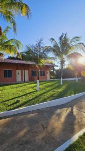 ein Haus mit Palmen vor einem Garten in der Unterkunft Hotel Villa Charmosa in São Pedro + 13 Fotos