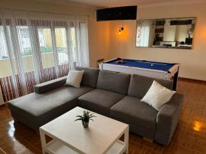 a living room with a couch and a pool table at Lisbonne et sa région en famille ou entre amis! in Alcoitão