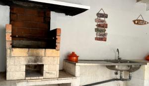 a kitchen with a brick fireplace and a sink at Lisbonne et sa région en famille ou entre amis! in Alcoitão +17 photos