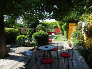 eine Terrasse mit einem Tisch und 4 Hockern in der Unterkunft Chambre d'Hotes "Riad des Baudières" in Bourg-en-Bresse