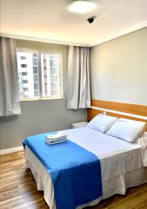 a bedroom with a large bed with a blue blanket at Hotel Porto Salvador in Salvador