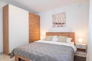 a bedroom with a large bed with two lamps on it at Apartment ILUX-2 in Novigrad Dalmatia