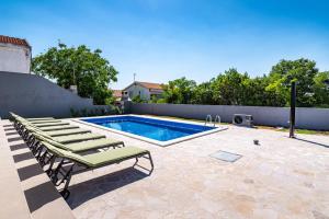 a swimming pool with chaise lounge chairs next to a swimming pool at Apartment ILUX-2 in Novigrad Dalmatia +9 photos